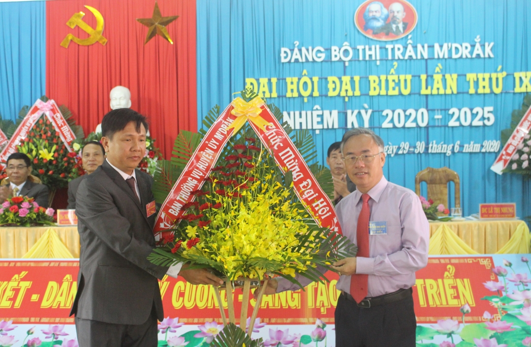 Phó bí thư Huyện ủy, Chủ tịch UBND huyện MĐrắk Hòa Quang Khiêm trao lẵng hoa tặng đại hội. 