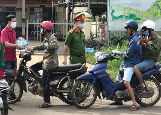 Cán bộ, chiến sĩ Công an phường Khánh Xuân (TP. Buôn Ma Thuột) phát khẩu trang y tế cho người dân. 