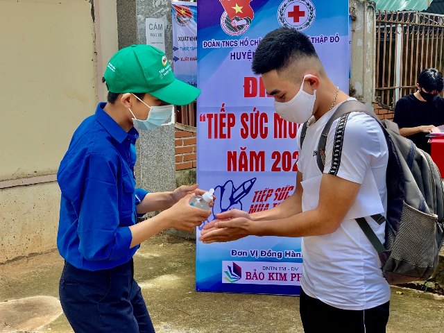 Lực lượng thanh niên tình nguyện hướng dẫn các thí sinh rửa tay trước khi vào điểm thi