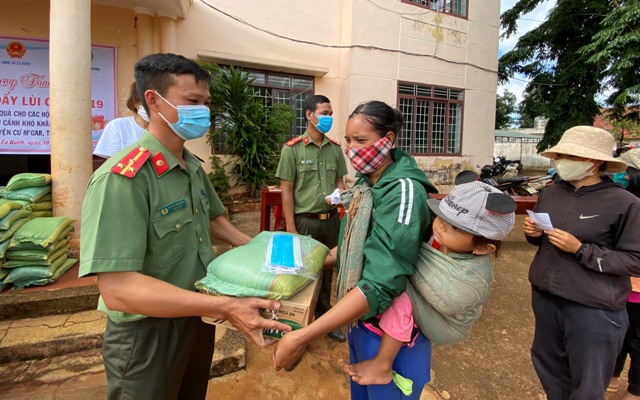 Đại diện Công an huyện Cư M'gar tặng quà cho các hộ nghèo xã Ea Kuêh.