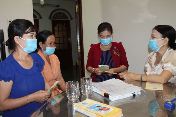 Bà Trương Thị Bông (bìa phải) tuyên truyền, vận động người dân trên địa bàn huyện tham gia BHXH tự nguyện.