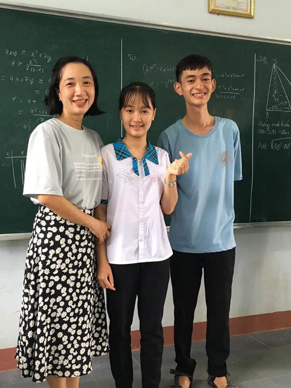 Em Nguyễn Phước Đắc Hùng (bìa phải) cùng cô giáo và bạn học. 