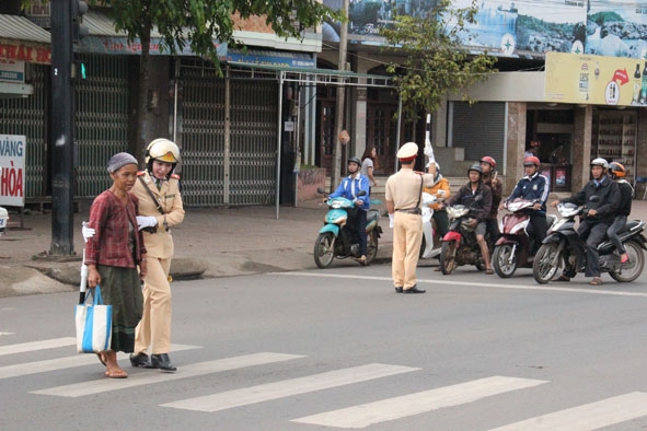 Chiến sĩ cảnh sát giao thông làm nhiệm vụ điều tiết giao thông và giúp người già qua đường.