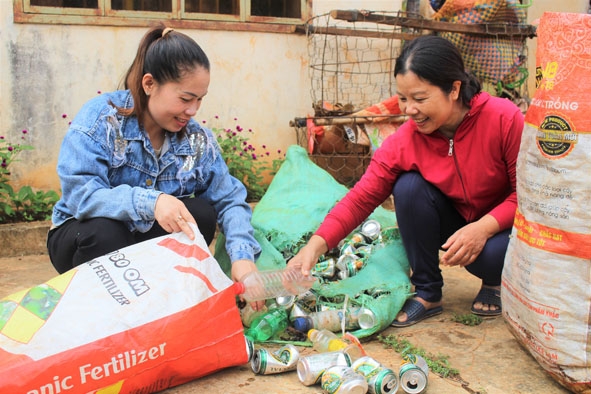 Các thành viên trong “Tổ phụ nữ  thu gom phế liệu” xã Ea Kênh  đang phân loại  phế liệu. 