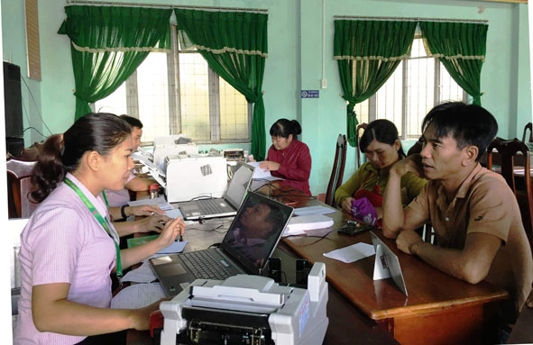 Cán bộ Ngân hàng chính sách xã hội huyện M'Drắk hướng dẫn người dân các thủ tục vay vốn.  