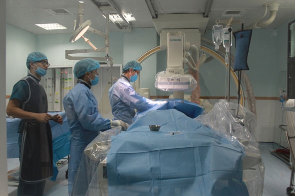Các bác sĩ Bệnh viện Đa khoa vùng Tây Nguyên thực hiện ca phẫu thuật đặt stent can thiệp tái thông tắc nghẽn động mạch vành.    Ảnh: Kim Oanh