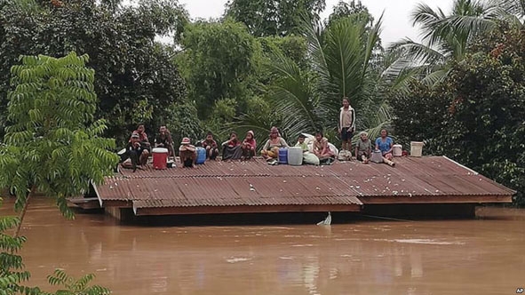 Nước ngập cao khiến nhiều người dân phải lên mái nhà chờ cứu hộ. (Nguồn: baothuathienhue.vn)