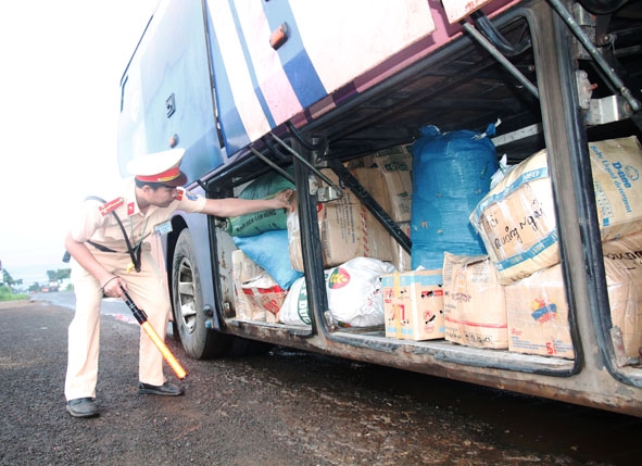 Lực lượng CSGT thuộc Trạm CSGT Krông Búk kiểm tra khoang chở hàng hóa trên xe khách. 