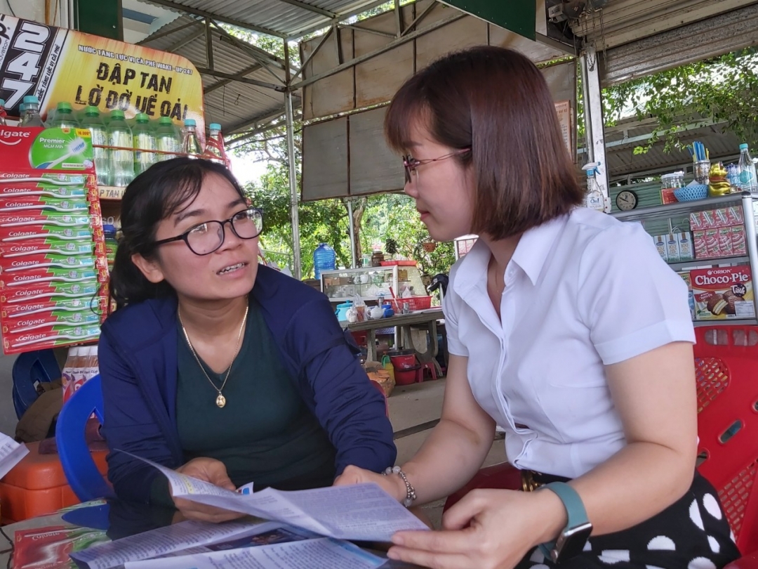 Cán bộ BHXH huyện Lắk tuyên truyền đến người dân về lợi ích khi tham gia BHXH tự nguyện. 