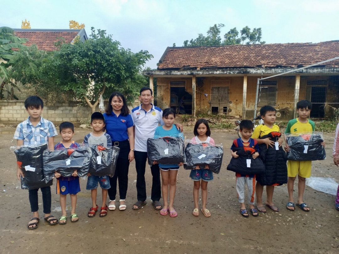 Đại diện CLB MC tỉnh Đắk Lắk (thứ 5 từ trái sang) tặng áo ấm cho học sinh tại huyện Lệ Thủy, tỉnh Quảng Bình. Ảnh: A.Phương
