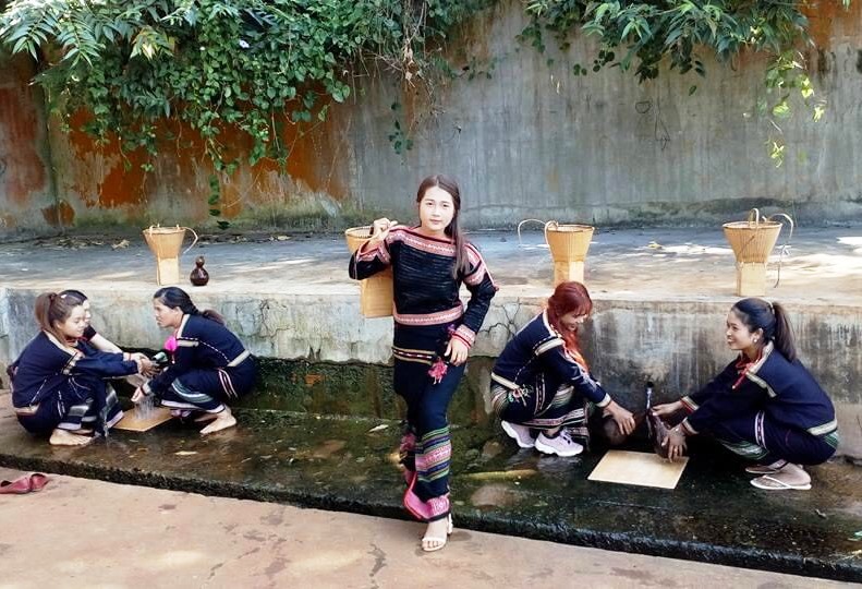 Các cô gái trẻ  ở buôn Wiâo A (thị trấn Krông Năng) dùng quả bầu hứng nước mát gùi về buôn  sau lễ cúng bến nước. 