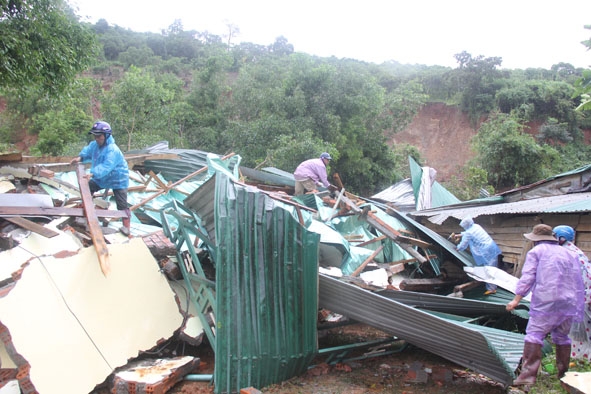 Các lực lượng chức năng và người dân xã Hòa Phong (huyện Krông Bông) giúp gia đình có nhà bị sập thu dọn đồ đạc.   Ảnh: Lê Thông