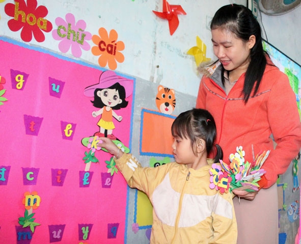 Cô Hương hướng dẫn học sinh làm quen với chữ cái Tiếng Việt bằng những đồ dùng học tập tự làm.