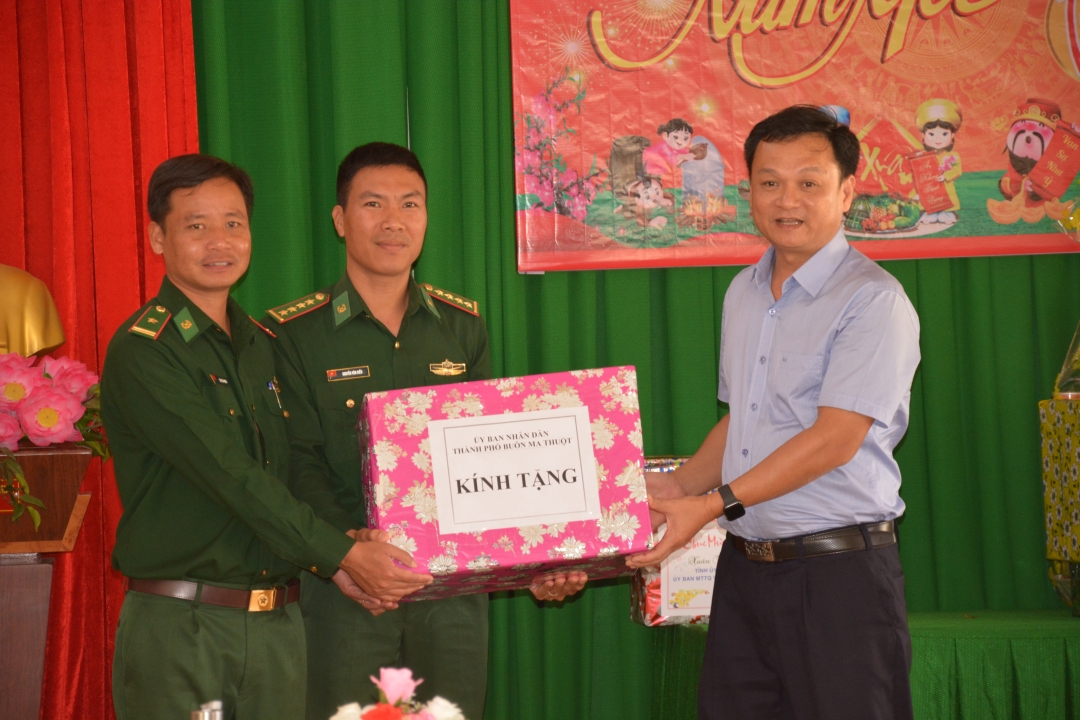 Chủ tịch UBND thành phố Buôn Ma Thuột Vũ Văn Hưng (bìa phải) tặng quà cán bộ, chiến sĩ Đồn biên phòng Bo Heng.