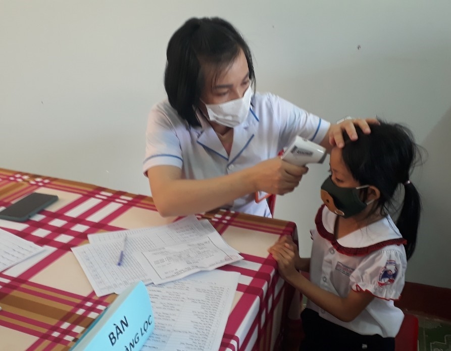Cán bộ y tế khám sàng lọc cho học sinh Trường Tiểu học Nguyễn Đức Cảnh (phường Tân Lợi, TP. Buôn Ma Thuột) trước khi tiêm vắc xin.   