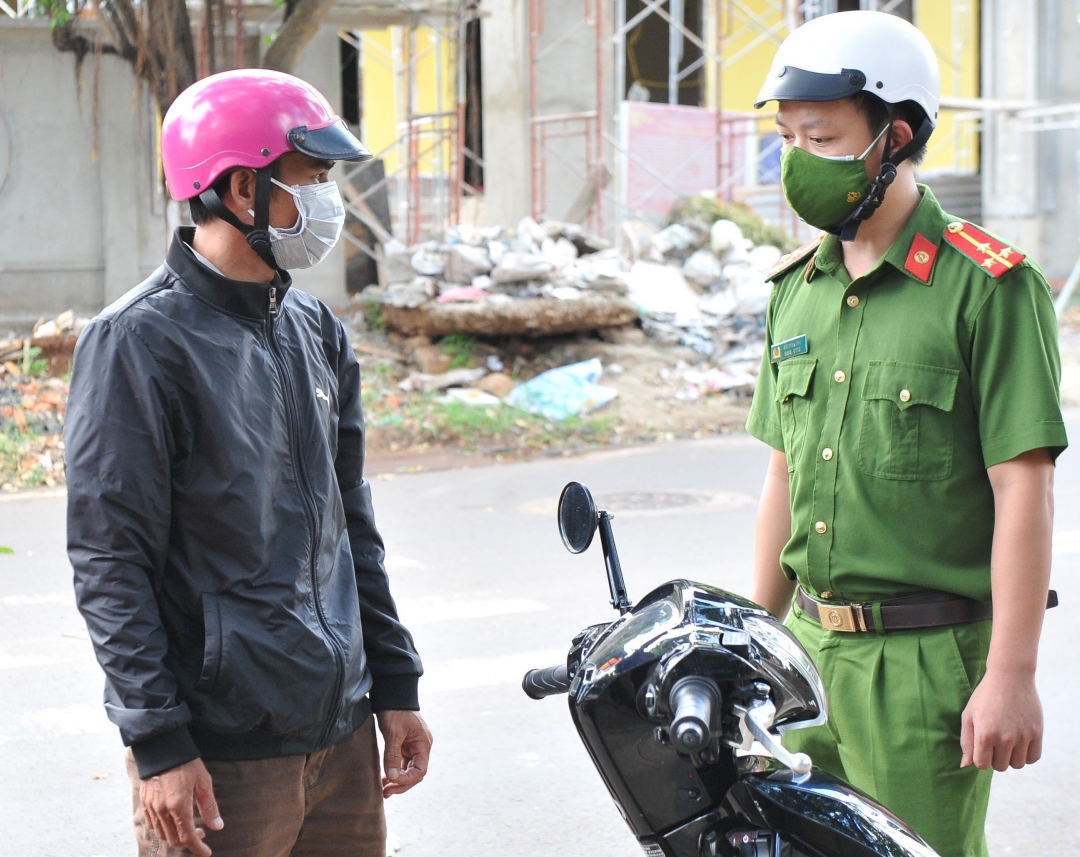 Cán bộ Công an phường Thành Công (TP. Buôn Ma Thuột) tuyên truyền, nhắc nhở người dân không ra đường khi không có lý do chính đáng. (Ảnh minh họa).