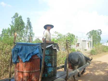 Người dân thôn 1 đi mua nước sạch về dùng.
