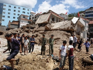 Nhân viên cứu hộ tìm kiếm các nạn nhân trong trận lở đất ở Chu Khúc.