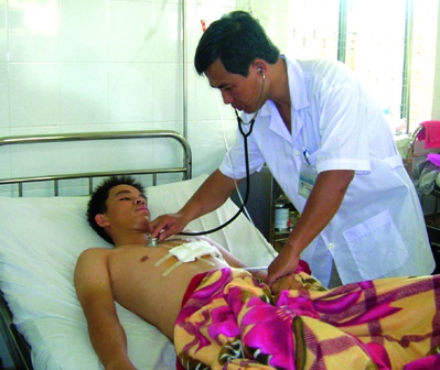 Bác sĩ Đào Anh Dũng đang kiểm tra tình trạng sức khỏe của bệnh nhân sau phẫu thuật.