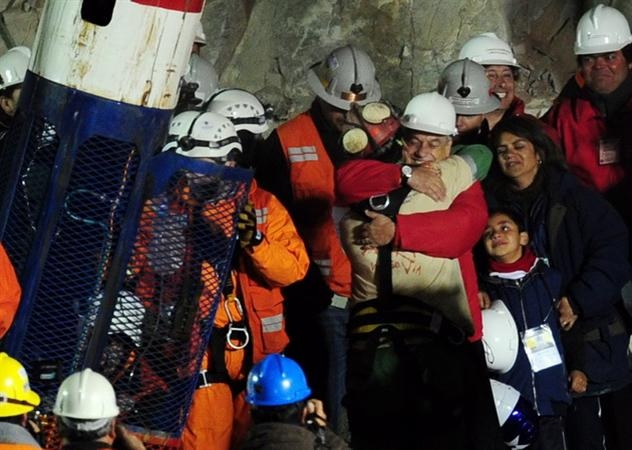 Tổng thống Chile Sebastian Pinera chúc mừng thợ mỏ Florencio Avalos (giữa, mặc trang phục thợ mỏ) khi anh vừa được đưa lên mặt đất. (Nguồn: AFP/