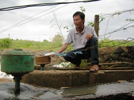 Trưởng thôn Lương Văn Lành bên những tua-bin phát điện.