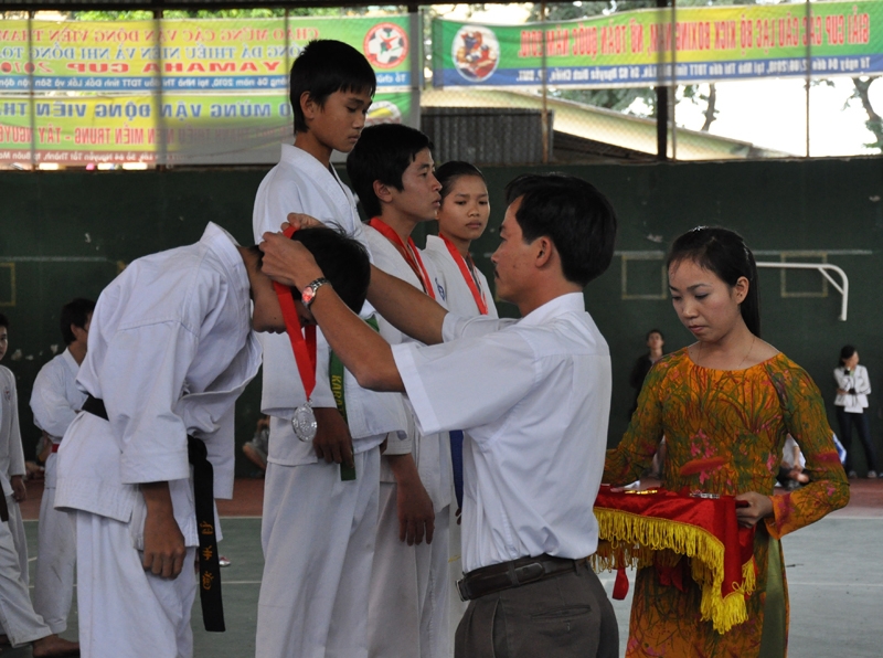 Ông Lê Xuân Hòa, Phó Giám đốc Trung tâm phát triển thể thao quần chúng tỉnh trao huy chương cho các VĐV ở nội dung Kumite nam, hạng cân 47 kg