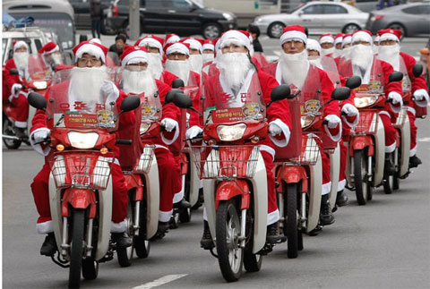 Những bưu tá Hàn Quốc mặc đồ ông già Noel đi xe máy đi đưa quà giáng sinh cho người nghèo trong chiến dịch từ thiện ở Seoul. Ảnh: AP