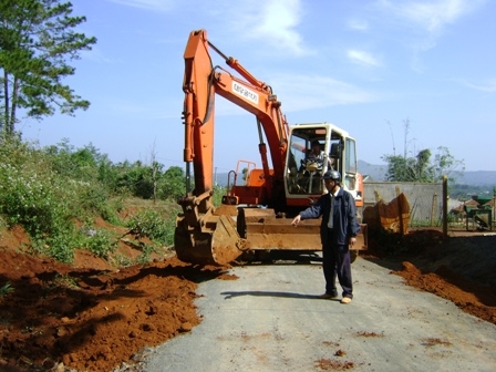 Cán bộ Phòng Kinh tế - Hạ tầng huyện Ea H'leo kiểm tra tiến độ làm đường giao thông tại xã Ea Nam, huyện Ea H'leo. (Ảnh: N.X)