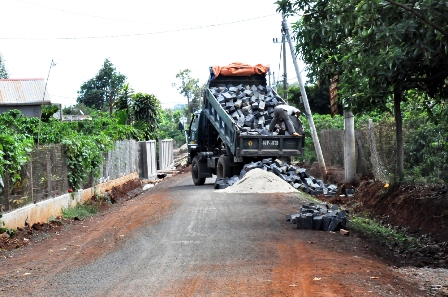 Người dân thôn 15 góp vật liệu để xây dựng lại tường rào sau khi con đường hoàn thành. (Ảnh: G.N)