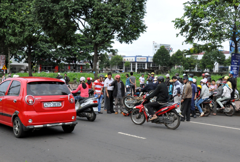 Rất đông người dân hiếu kỳ dựng lại xem vụ tai nạn khiến một đoạn đường Nguyễn Tất Thành bị kẹt xe cục bộ