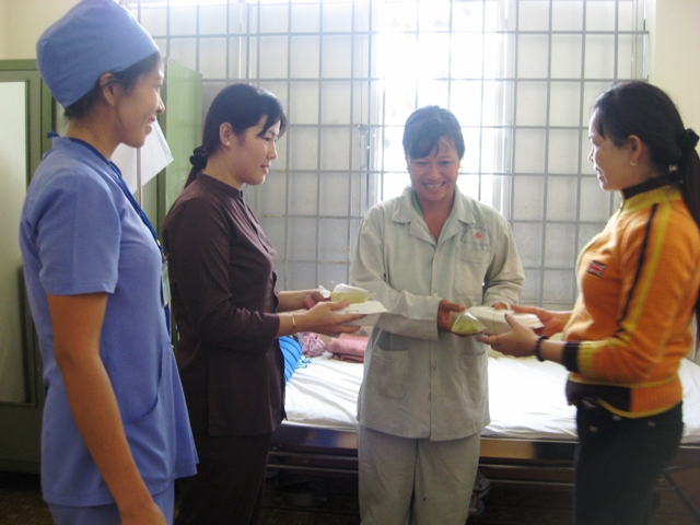 Bà con phật tử Niệm phật đường An Bình đang trao những suất cơm từ thiện cho bệnh nhân (đứng giữa) điều trị tại Bệnh viện Đa khoa huyện Buôn Đôn.