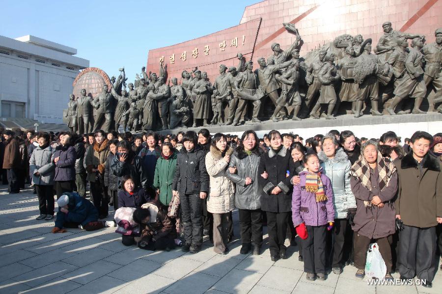 Mọi người tụ tập ở phía trước của một bức tượng đồng của Kim Il Sung ở trung tâm Bình Nhưỡng để thương tiếc cái chết của Kim Jong Il, nhà lãnh đạo hàng đầu của Cộng hòa Dân chủ Nhân dân Triều Tiên (CHDCND Triều Tiên) ở Bình Nhưỡng, CHDCND Triều Tiên, ngày 19 tháng 12 năm 2011. (Tân Hoa Xã / Zhang Li)