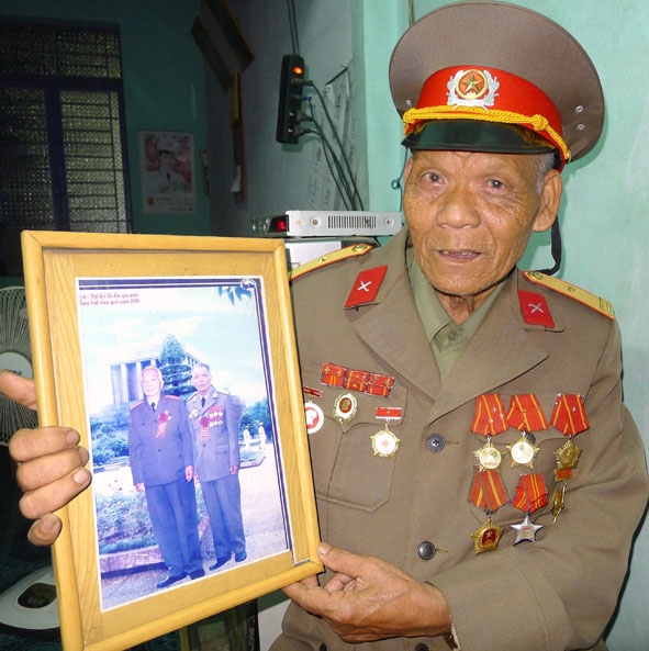 Cụ Vinh và bức ảnh chụp chung cùng Đại tướng Võ Nguyên Giáp.   
