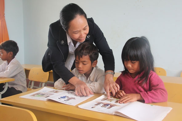 Cô Trần Thị Hạnh, giáo viên Trường Tiểu học Nơ Trang Lơng (xã Ea Yông, huyện Krông Pak) hướng dẫn học sinh làm quen với các dụng cụ học tập qua tranh ảnh.  
