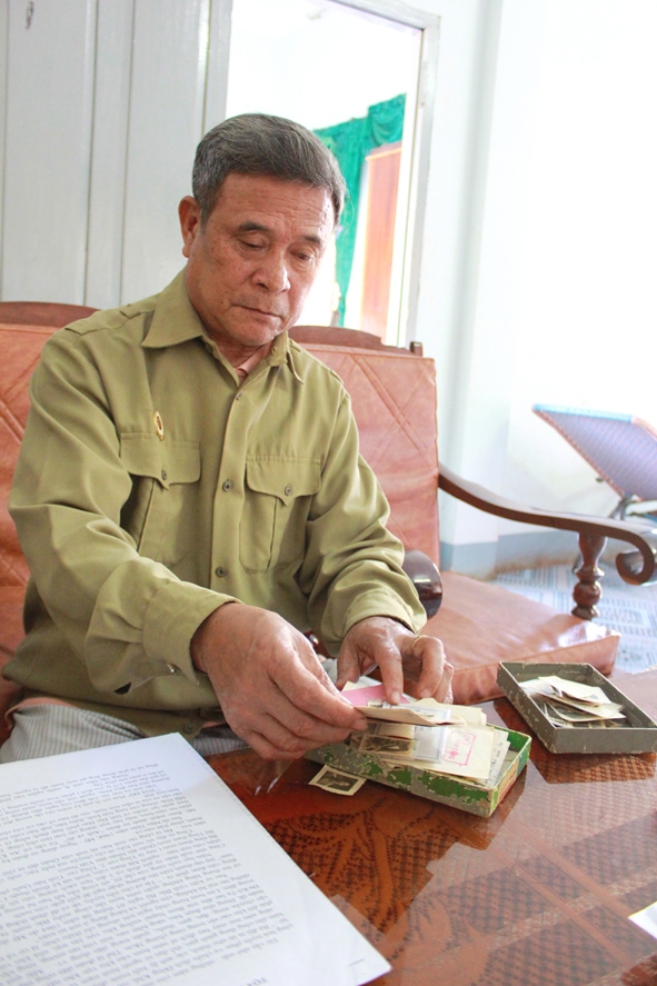Ông Vũ Văn Tăng đang xem lại những bức hình  kỷ niệm chụp ở chiến trường. 