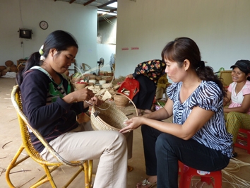 Dương Thị Phương (phải) đang hướng dẫn người dân đan bình ủ ấm trà.