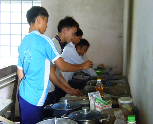 Học sinh Trường THCS Cư Pui chuẩn bị bữa trưa tại nhà Bán trú dân nuôi.