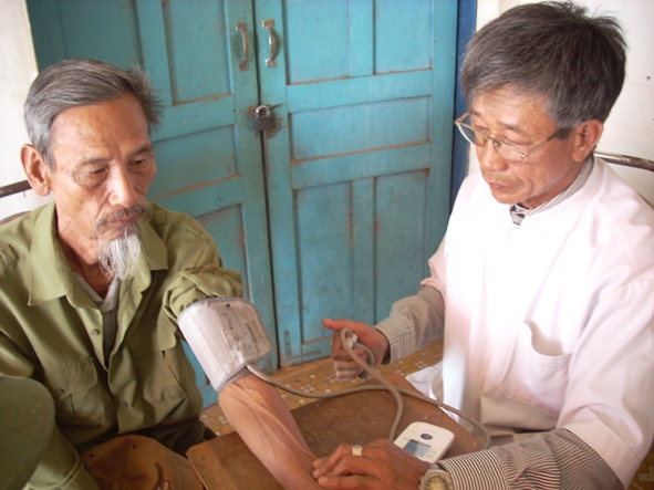 Lương y Hoàng Văn Cường (phải)  đang khám cho bệnh nhân.