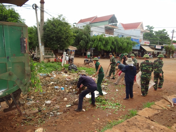 Đoàn viên thanh niên Chi đoàn Quân sự huyện Cư Mgar phối hợp với công nhân môi trường huyện dọn rác thải.                                            Ảnh: Trung Hải