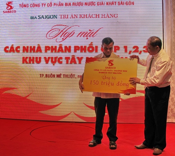Ông Y Dec H’Dơk, Chủ tịch UBMTTQVN tỉnh Dak Lak (trái) nhận tượng trưng số tiền 150 triệu đồng do đại diện CTCP Thương mại Sabeco Tây Nguyên ủng hộ Quỹ 