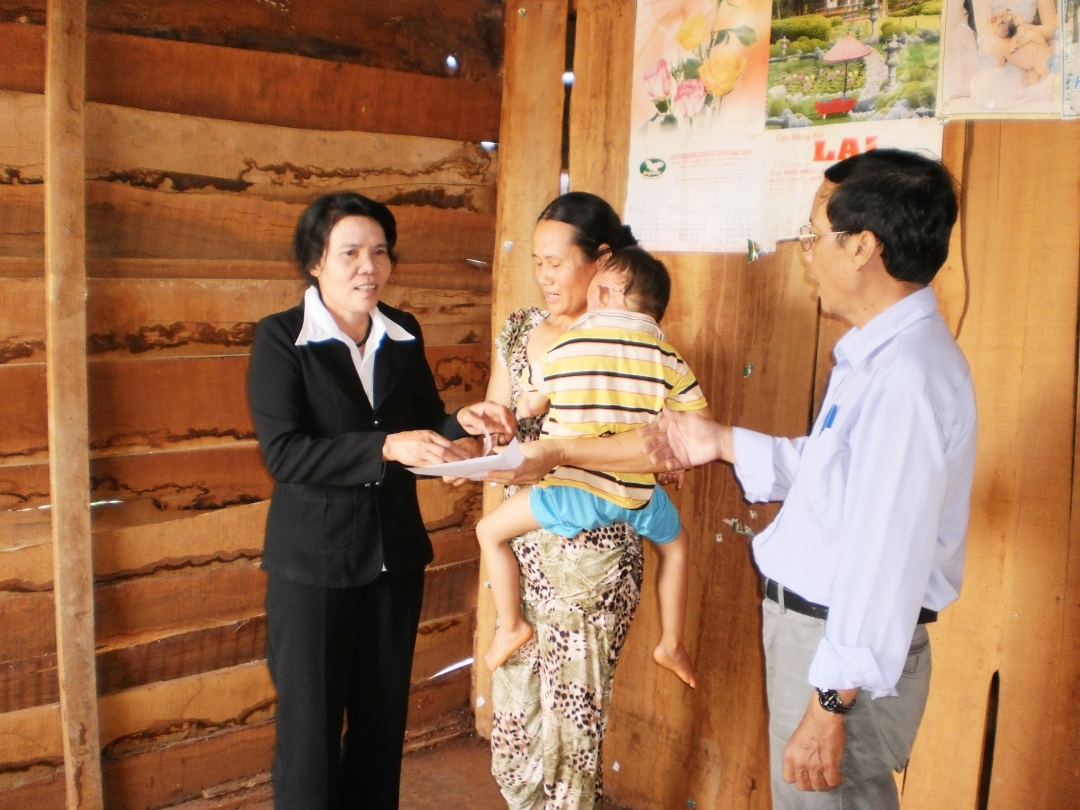 Bà Nhật (ngoài cùng bên trái) tặng quà một gia đình có hoàn cảnh  khó khăn ở huyện Cư M'gar.