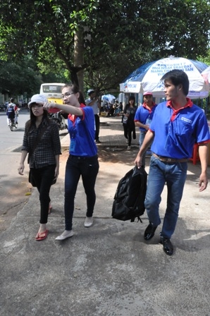 Các thành viên đội tiếp sức mùa thi mang hành lý giúp thí sinh đến điểm trọ