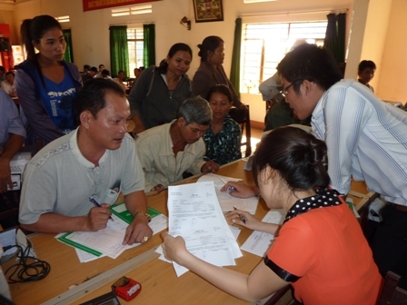 Cán bộ tín dụng Chi nhánh NH Chính sách xã hội Dak Lak (phải) hướng dẫn phụ huynh làm thủ tục vay vốn tín dụng HSSV