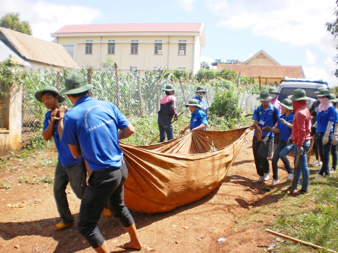 Các chiến sĩ tình nguyện tổng dọn vệ sinh môi trường giúp người dân buôn Kra (xã Ea Hiao, huyện Ea H'leo).