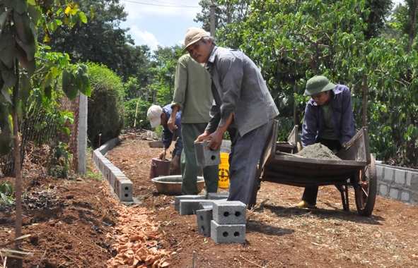 Người dân xã Ea Ning (Cư Kuin) tự nguyện di dời tường rào của gia đình để làm đường giao thông.