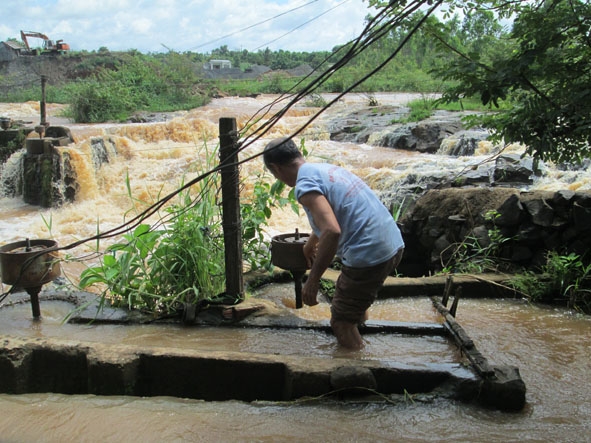 Ông Nông Đức Hồng đang sửa tua-bin phát điện của gia đình mình.