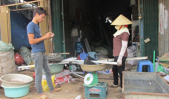 Anh Vũ Văn Chấp đang cân phế liệu cho người thu mua gom.