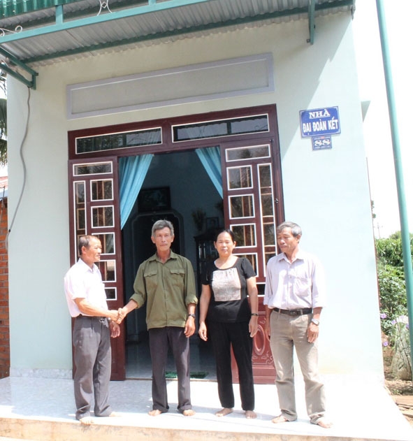 Vợ chồng anh Giang trước ngôi nhà  mới xây nhờ quỹ nuôi heo đất tiết kiệm của xã.