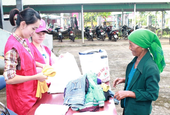 Tình nguyện viên Hội Chữ thập đỏ huyện cấp tặng áo quần cũ cho người nghèo.