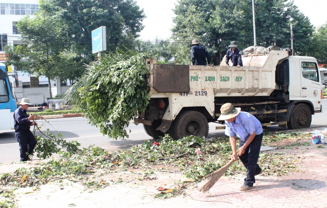 Công nhân Công ty TNHH Một thành viên Quản lý Đô thị và Môi trường Dak Lak làm vệ sinh môi trường trên đường Nguyễn Tất Thành, TP. Buôn Ma Thuột.   Ảnh: Thúy Hồng